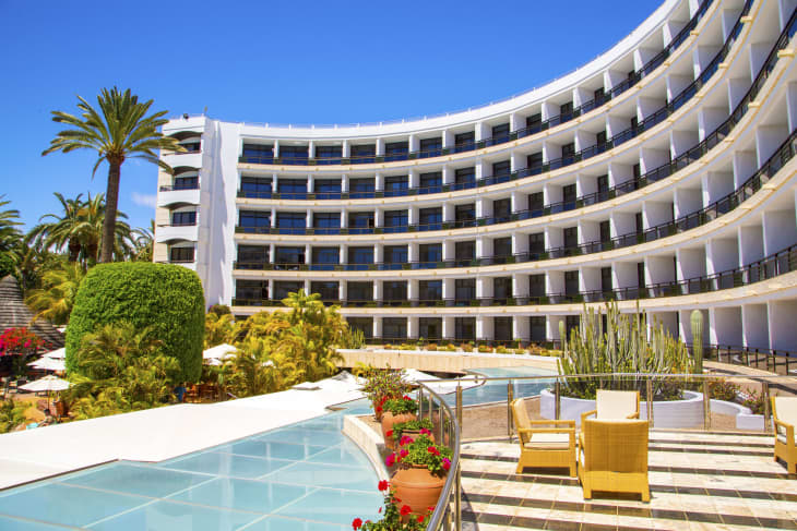 Luxury hotel with infinity pool and palms all around it.