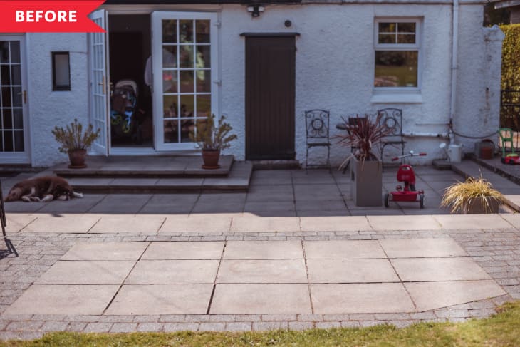 Patio with potted plants, a red tricycle, and a dog lying near open French doors.