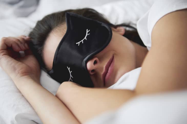 Portrait of young woman with sleep mask in bed.