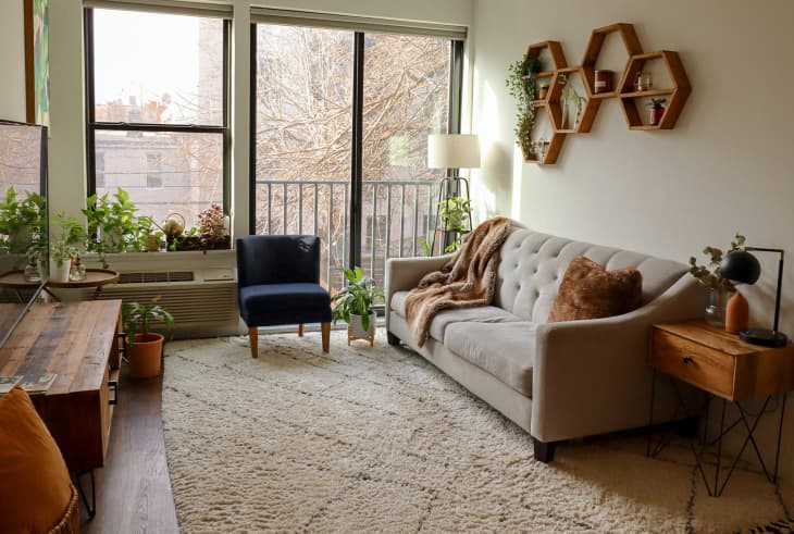 Living room with large windows and hexagonal shelves hanging on wall