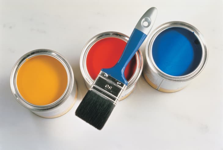 Interior and Decoration - a group of colorful paint cans with paintbrush isolated on silver background