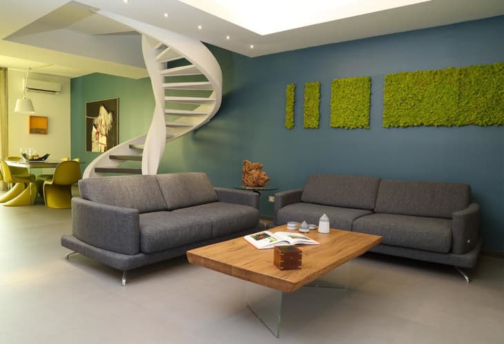 Living area with spiral staircase and moss wall art