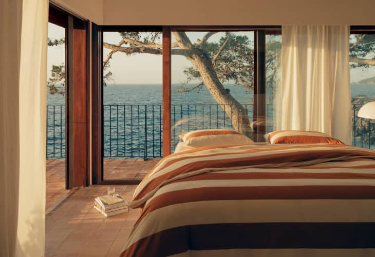 Mango Home duvet in neutral stripes with an ocean view outside of the bedroom