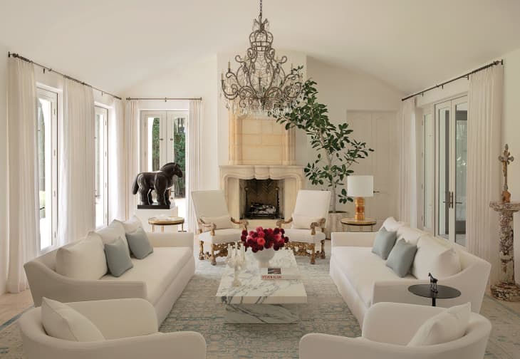 Sofia Vergara's Los Angeles home white living room with large chandelier and ornate fireplace