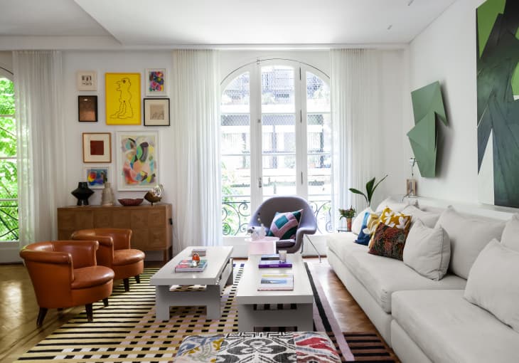 Buenos Aires, Argentina house tour living room. Large light gray sofa, patterned rug, textiles, white walls, large windows