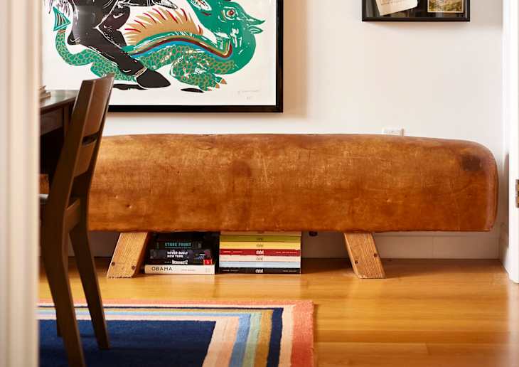 Hallway through to a room with large framed art and a colorful couch.