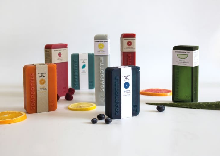 Colorful soap bottles with fruit slices and aloe, featuring labels like "Cleansing Gel in Soap" and "Shampoo in Soap."