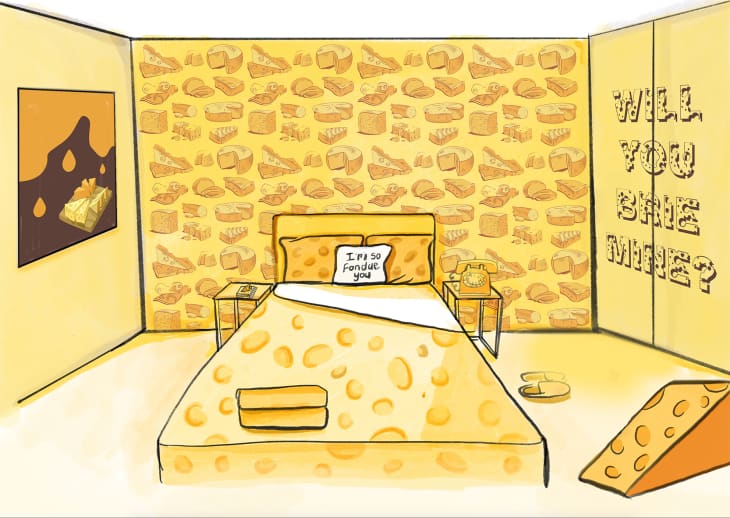 Cheese-themed bedroom with cheese-patterned bedding, cheese wallpaper, and a pillow saying "I'm so fondue you."
