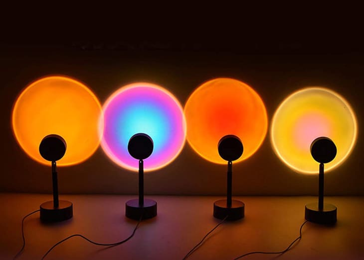 Four lamps projecting circles in sunset colors on wall