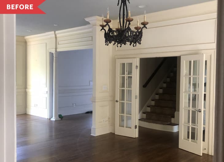 Before: Traditional dining room with brown wood floors and white walls, plus a black chandelier