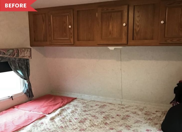 Before: Bed with floral quilt beneath brown wooden cabinets