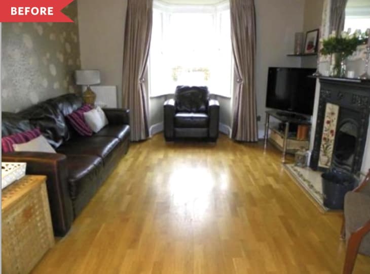 Living room with brown leather sofas, wooden floor, TV, and fireplace, before renovation.