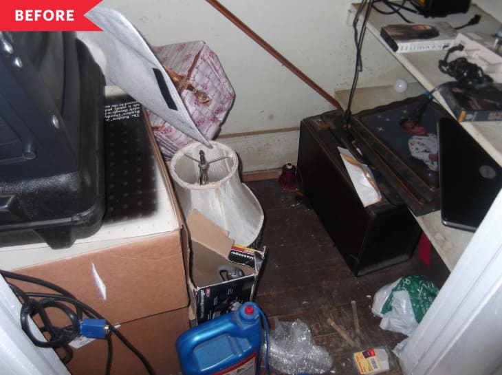 Cluttered storage room with boxes, a lamp, a suitcase, and scattered items on the floor.