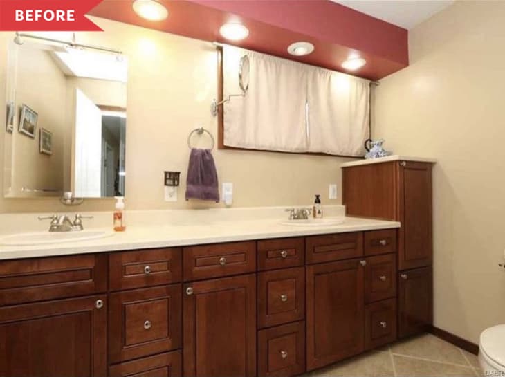 Bathroom with wooden cabinets, dual sinks, purple towel, and beige walls under recessed lighting.