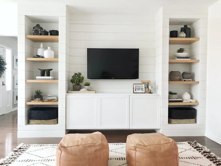 A white-and-wood media unit surrounding a TV, built around an IKEA BESTA console.