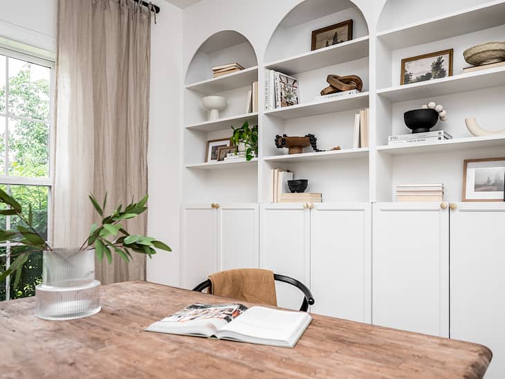 White Ikea Billy bookcase with doors on bottom in dining room.
