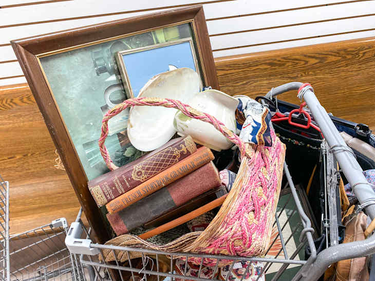 Shopping cart filled with items at thrift store.