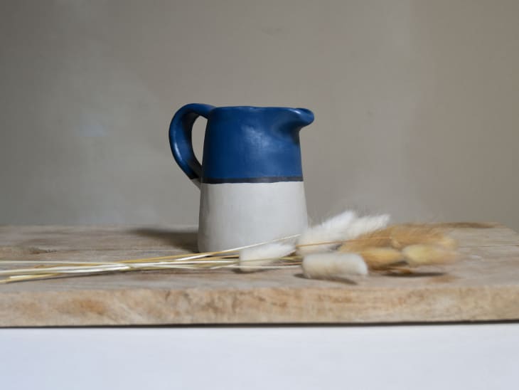 Handmade pitcher next to dried grass stems
