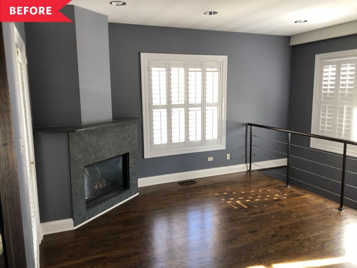 Before: Empty living room with dark gray walls, wood floors, fireplace, and metal railing