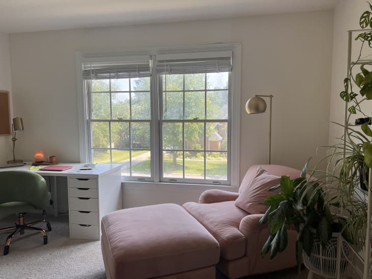 Office with white large desk, pink cozy lounge chaise, plants, and art