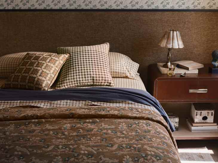 Bed with plaid and tapestry linens