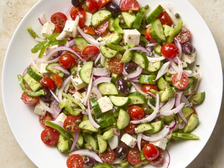 overhead shot of a greek salad in a large white serving bowl.