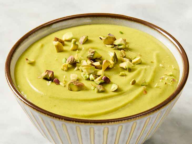 Creamy green dessert in a bowl, topped with chopped pistachios.