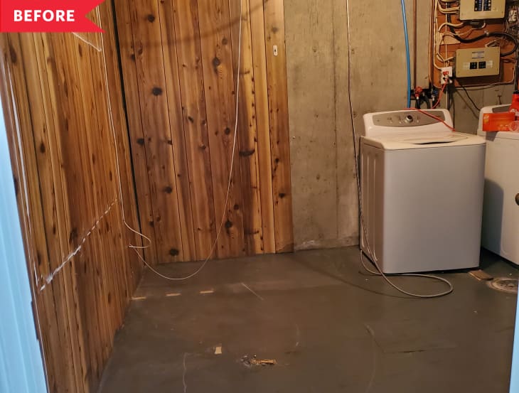 Before: Laundry area in unfinished basement with wood paneling and wires overhead