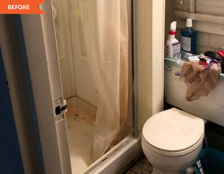 Cluttered bathroom with a dirty shower, toilet, and sink covered in cleaning products and toiletries.