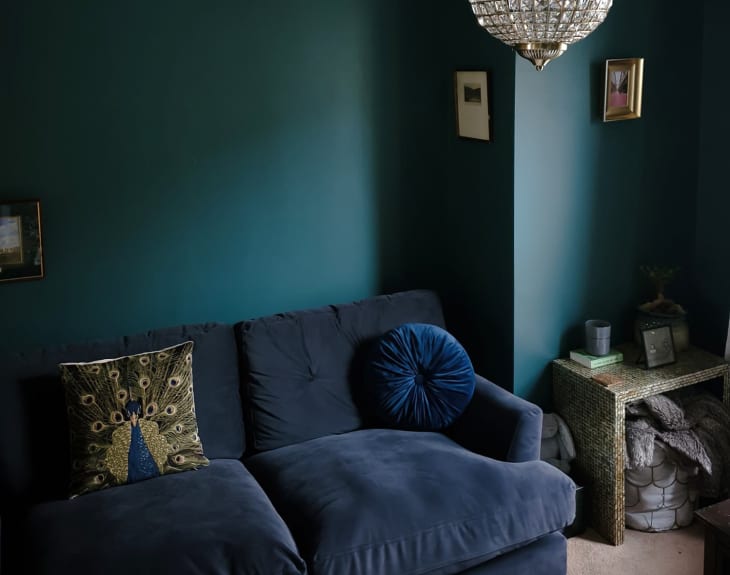 Living room with deep green walls and navy sofa