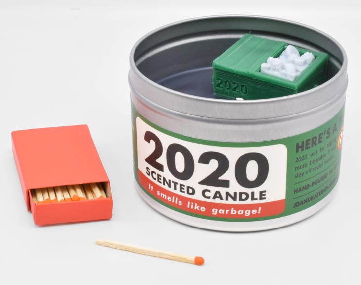 Candle in tin with green lable and orange box of matches