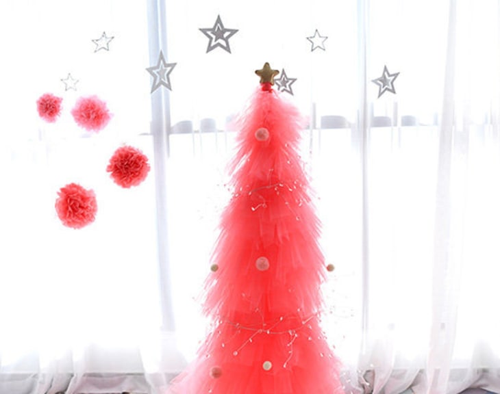 Hot pink tulle tree with star and pom decorations hanging above
