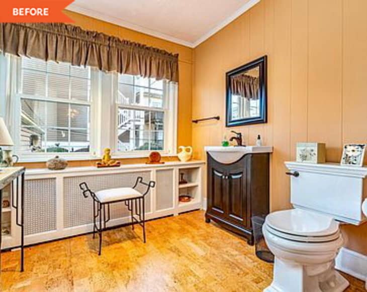 Before: full view of a tan bathroom with large windows and a dark drown sink
