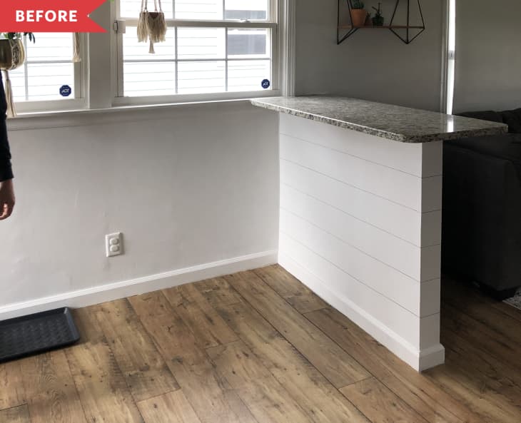 Before: Empty dining space with a half-wall featuring a bar counter