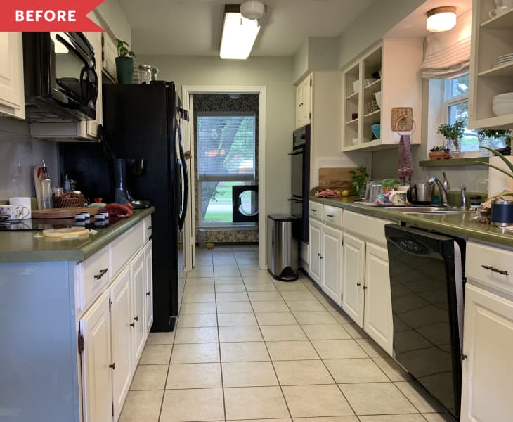 Galley kitchen with white cabinets, green countertops, black appliances, and open shelving, leading to a windowed door.