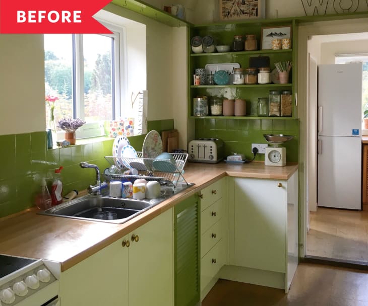 Small kitchen with green tile backsplash, wooden countertops, dish rack, toaster, and jars on shelves.