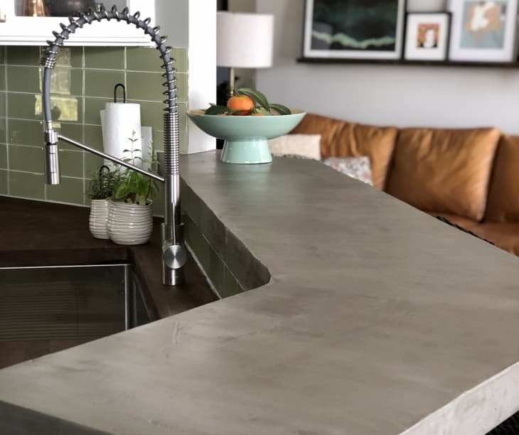 Island countertop with feathered concrete finish in gray color.