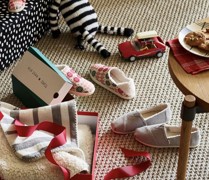 West Elm x TOMS collaboration for 2021 of indoor/outdoor slip-ons and slippers in rose, gray, and a modern Welsh-inspired pattern with a blanket shown too