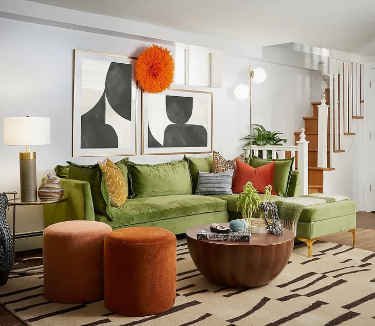Green suede sectional in living room with burnt orange pops of color.