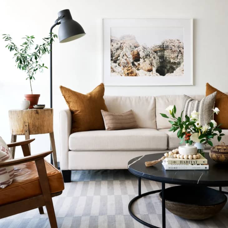 a beige sofa with rust/burnt orange throw pillows