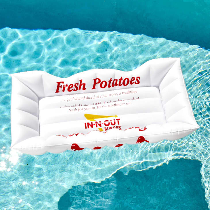 Inflatable pool float with "Fresh Potatoes" and "In-N-Out Burger" logos on clear blue water.