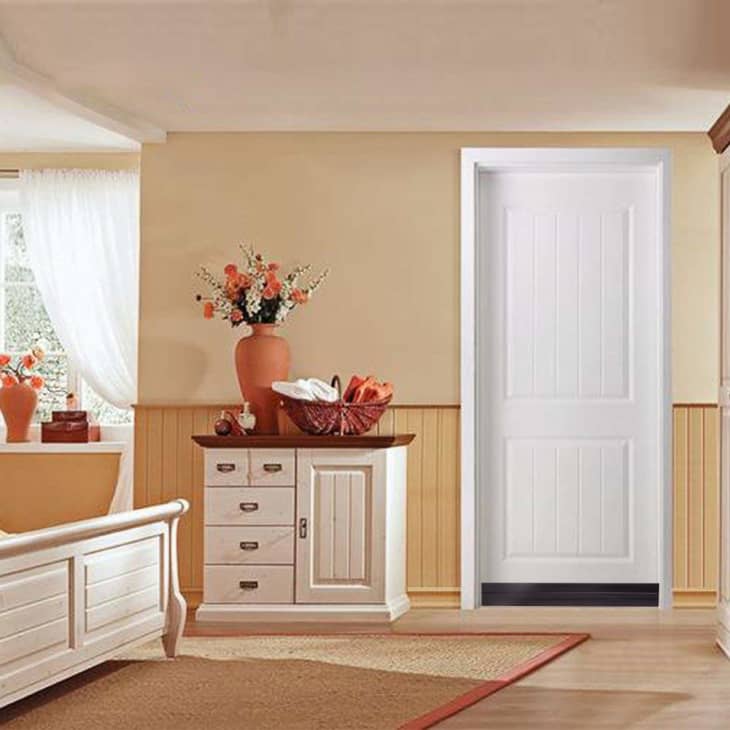 Bedroom with white furniture, a dresser with drawers, a vase of flowers, and a basket on top.