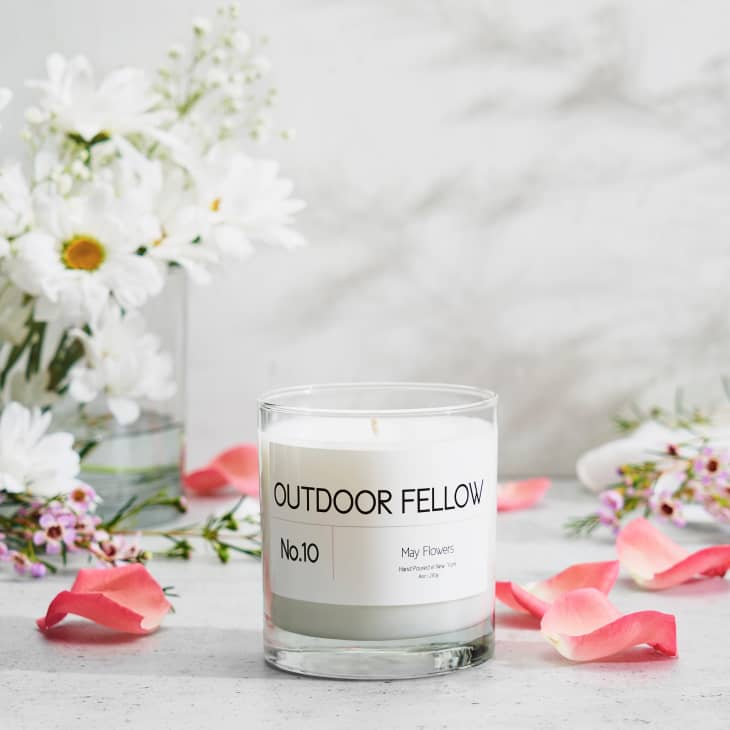 Scented candle labeled "Outdoor Fellow No.10" with pink petals and white flowers in a vase.