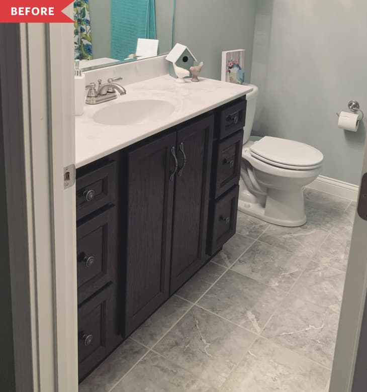 Small bathroom with dark wood vanity, white countertop, toilet, and gray tile floor.