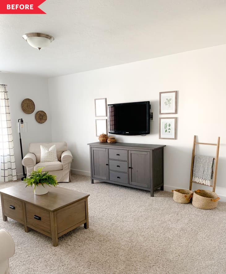 Living room with beige armchair, gray TV stand, wall-mounted TV, coffee table, and decorative baskets.