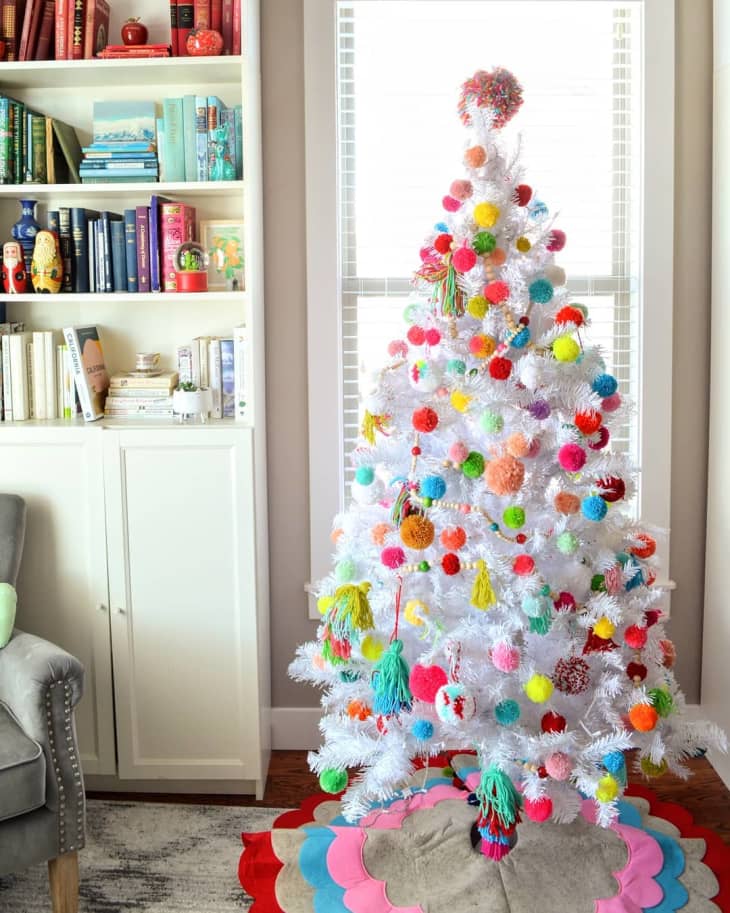 white Christmas tree covered in pom pom and tassel ornaments