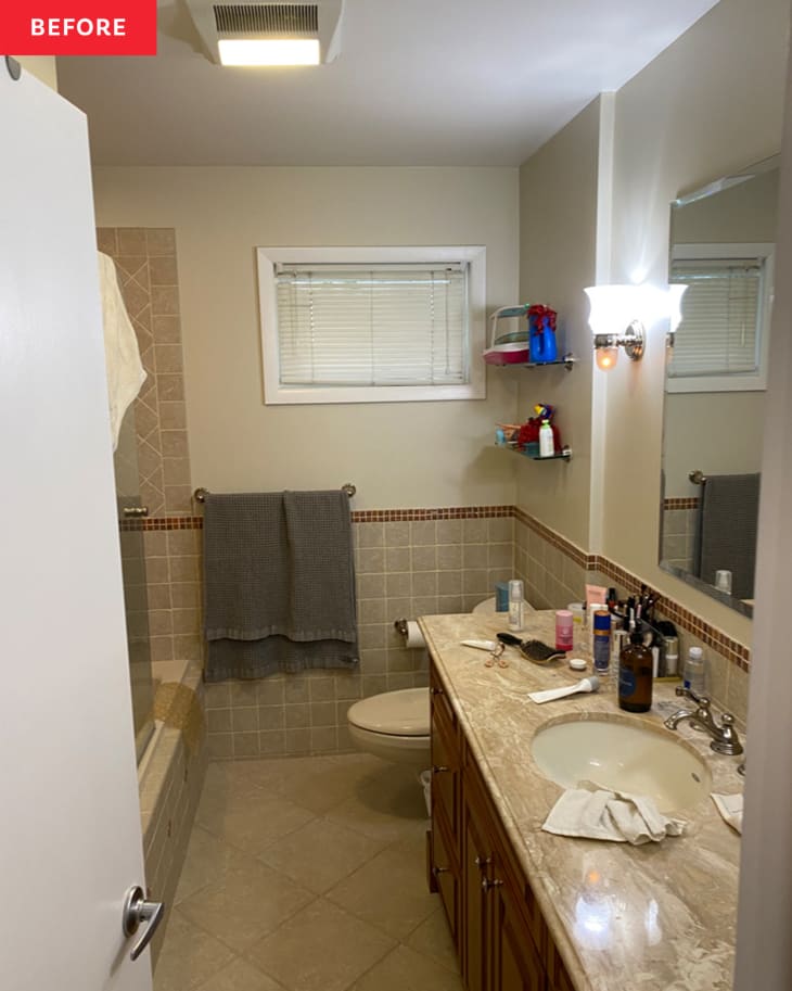 Bathroom before renovation/makeover: outdated marble-look countertop and wood cabinets, brownish gray tiles on lower half of wall and in shower, drab warm gray tile floor