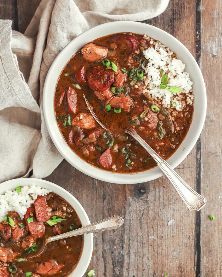 Cajun chicken and sausage gumbo in white bowl with a silver spoon