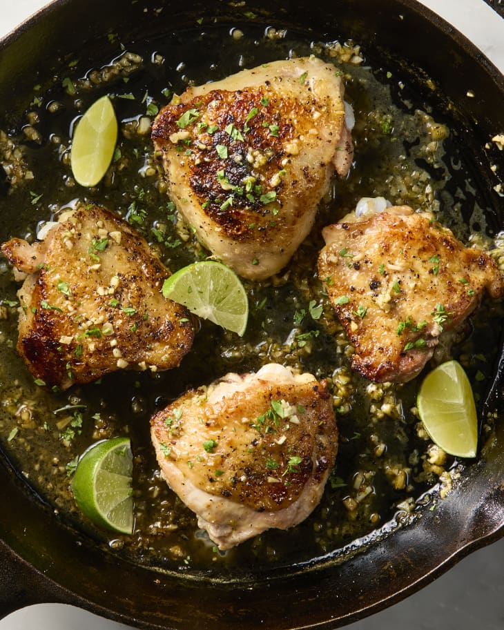 overhead shot of four garlic lime chicken thighs, in a cast iron pan.