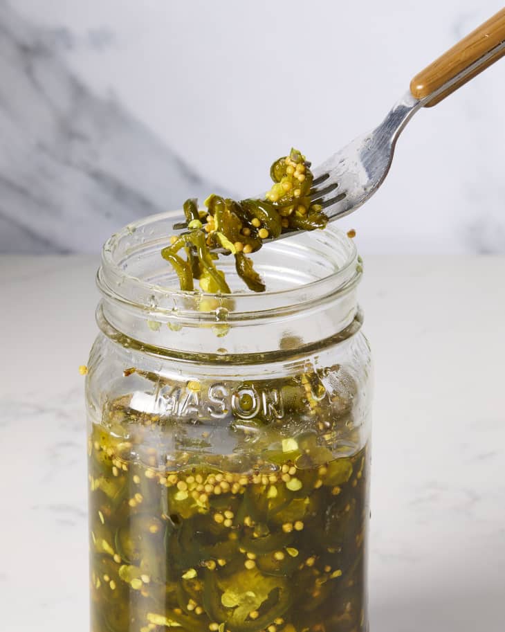 head on shot of cowboy candy being taken out of a mason jar with a fork